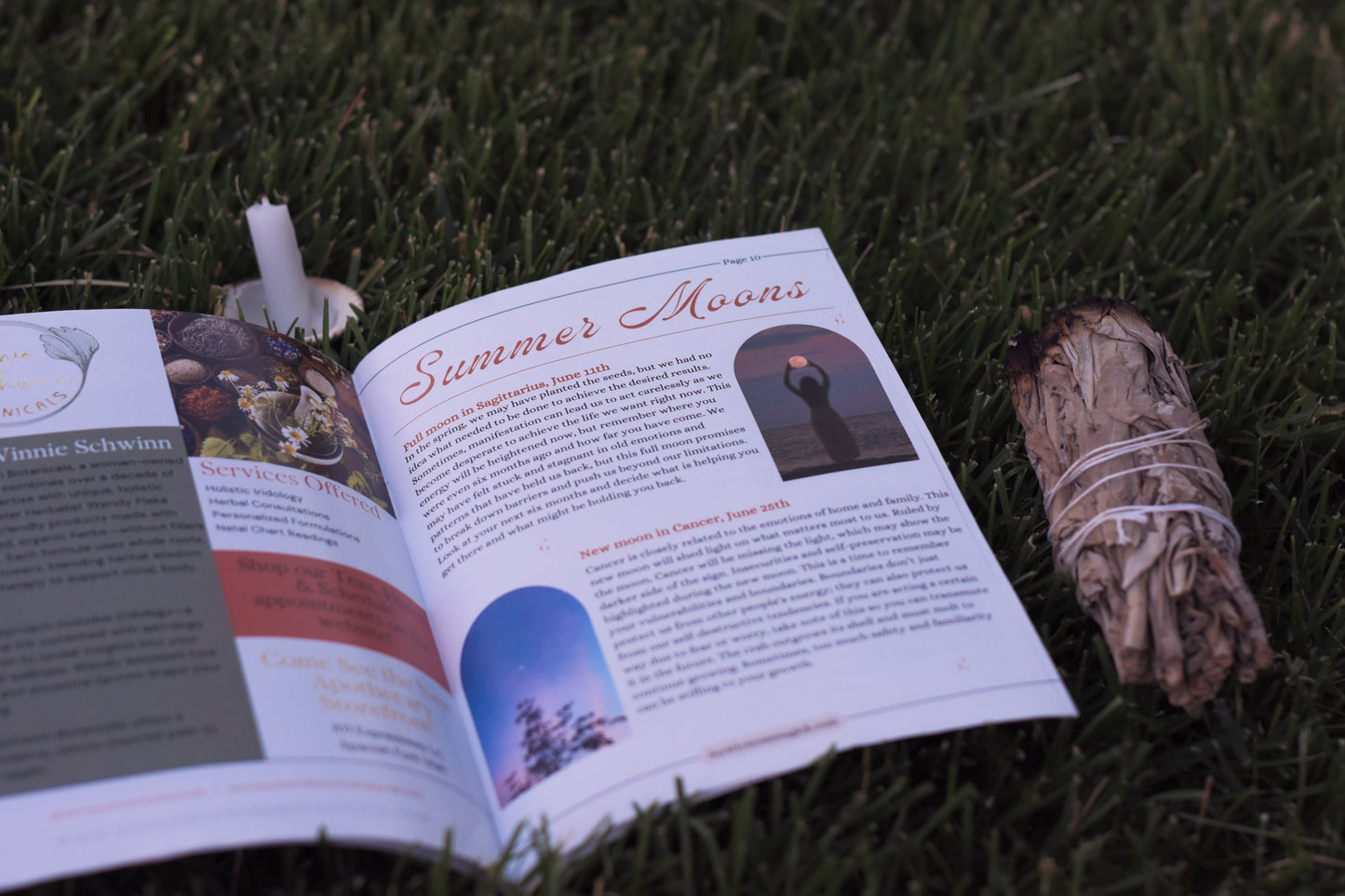 Flat lay of summer witchcraft magazine with herbs, candles, and ritual items for seasonal spiritual practices